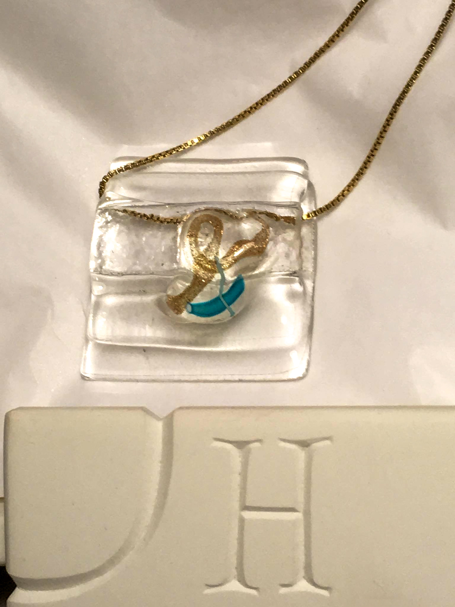 Twee glazen oorstekers met bladgoud erin verwerkt, handgemaakte glasjuwelen met een schittering.